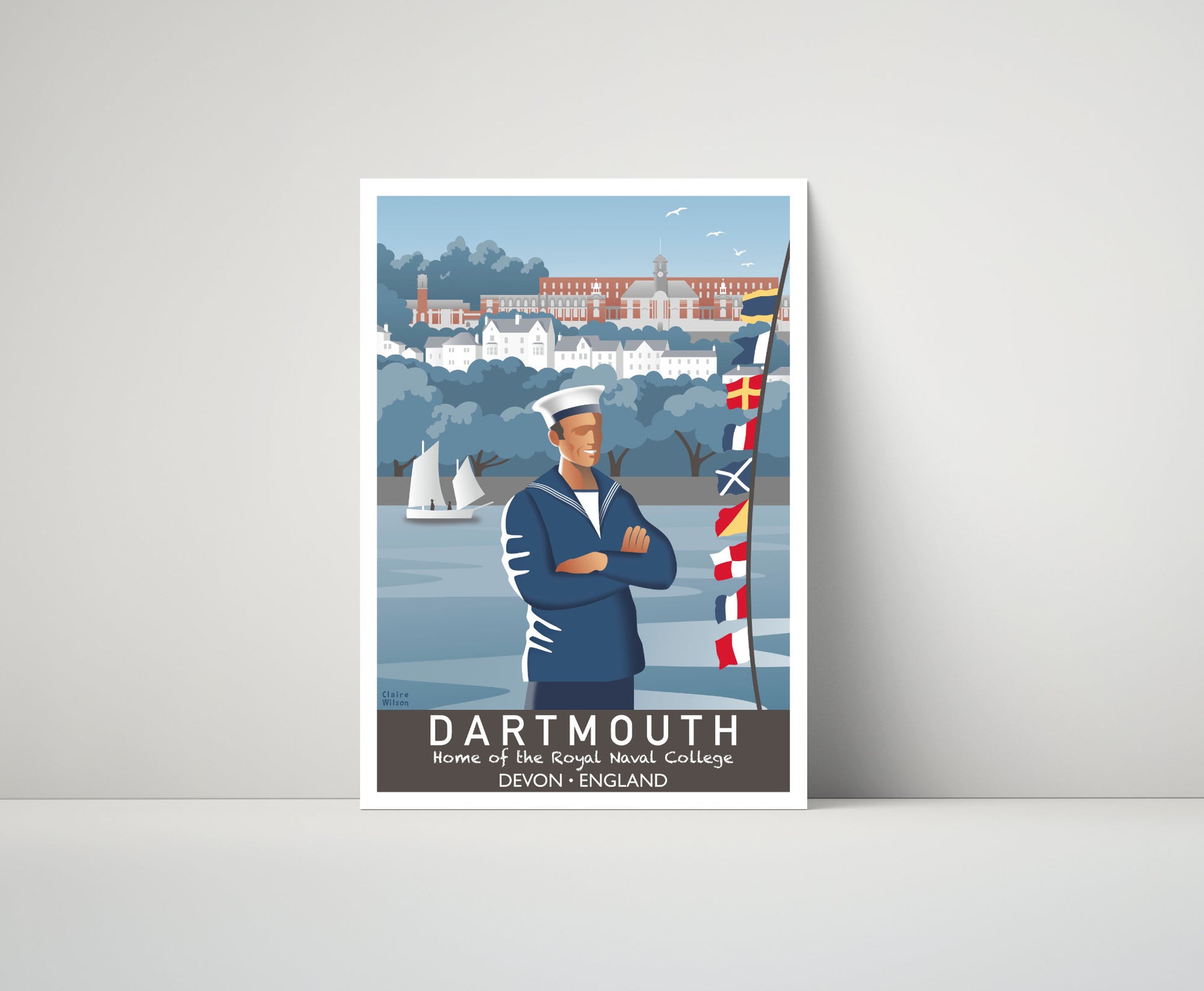 Artwork of a seafarer and maritime flags at Dartmouth riverside, with a naval college in the distance 