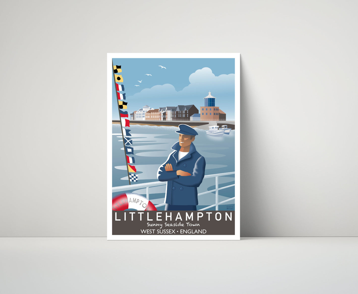 Artwork of a fisherman and maritime flags at Littlehampton harbour, with riverside apartments in the distance 