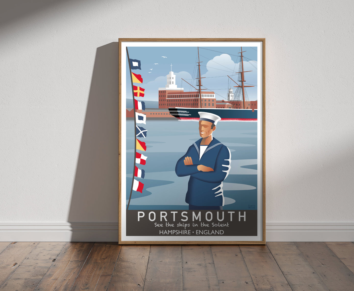 Framed illustration of a sailor and nautical flags at Portsmouth harbour, with naval buildings and an old ship in background 