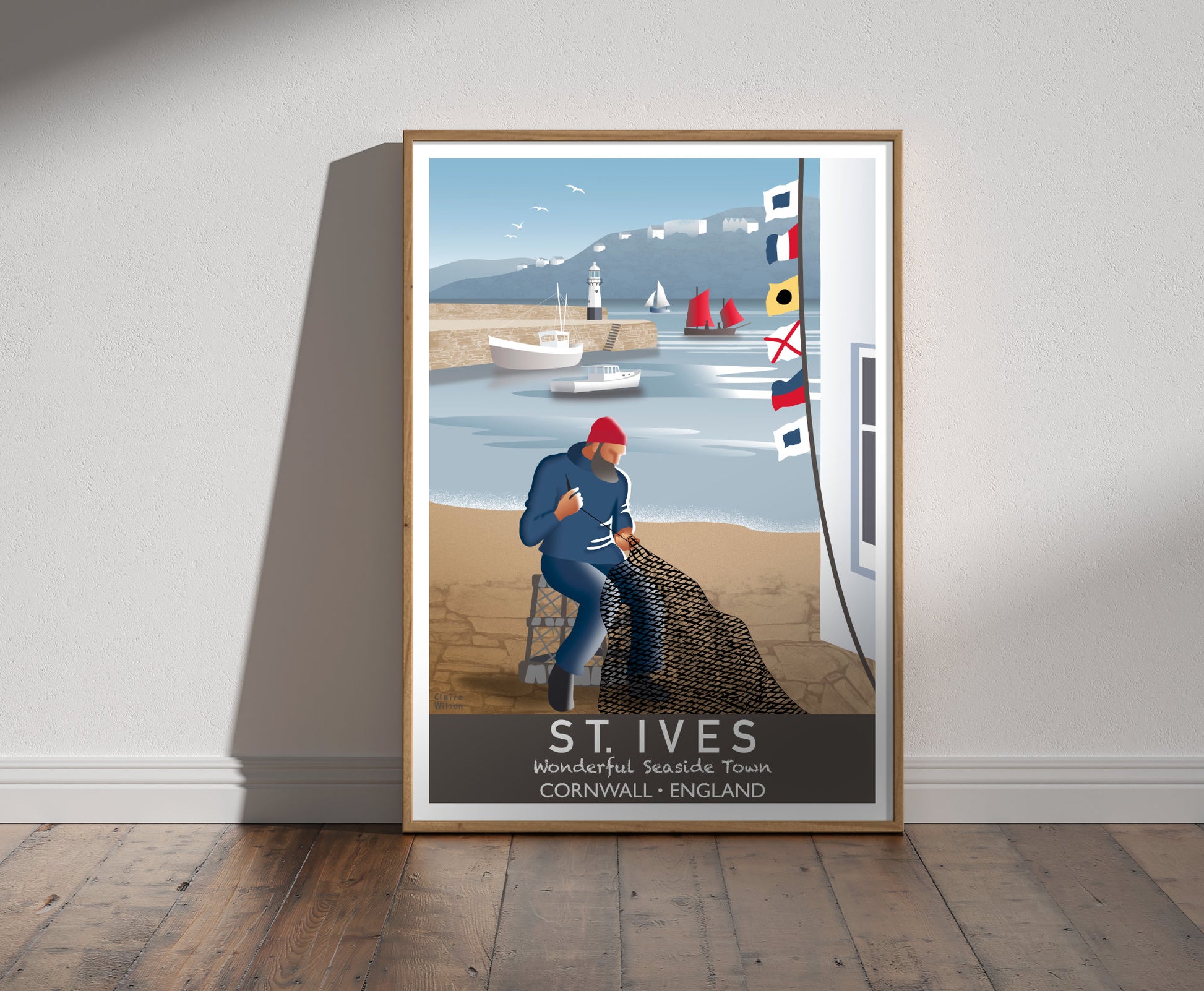 Framed illustration of a fisherman mending his nets by the harbour at St Ives, with nautical flags, boats, and a lighthouse in background 