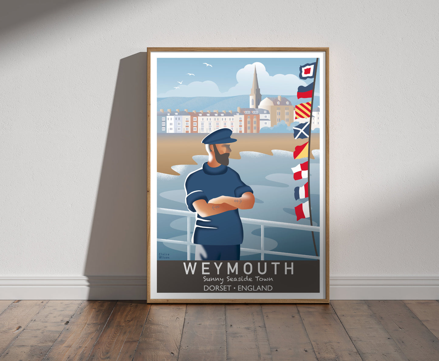 Framed illustration of a sailor and nautical flags at Weymouth seafront, with old church, and seaside town in background 