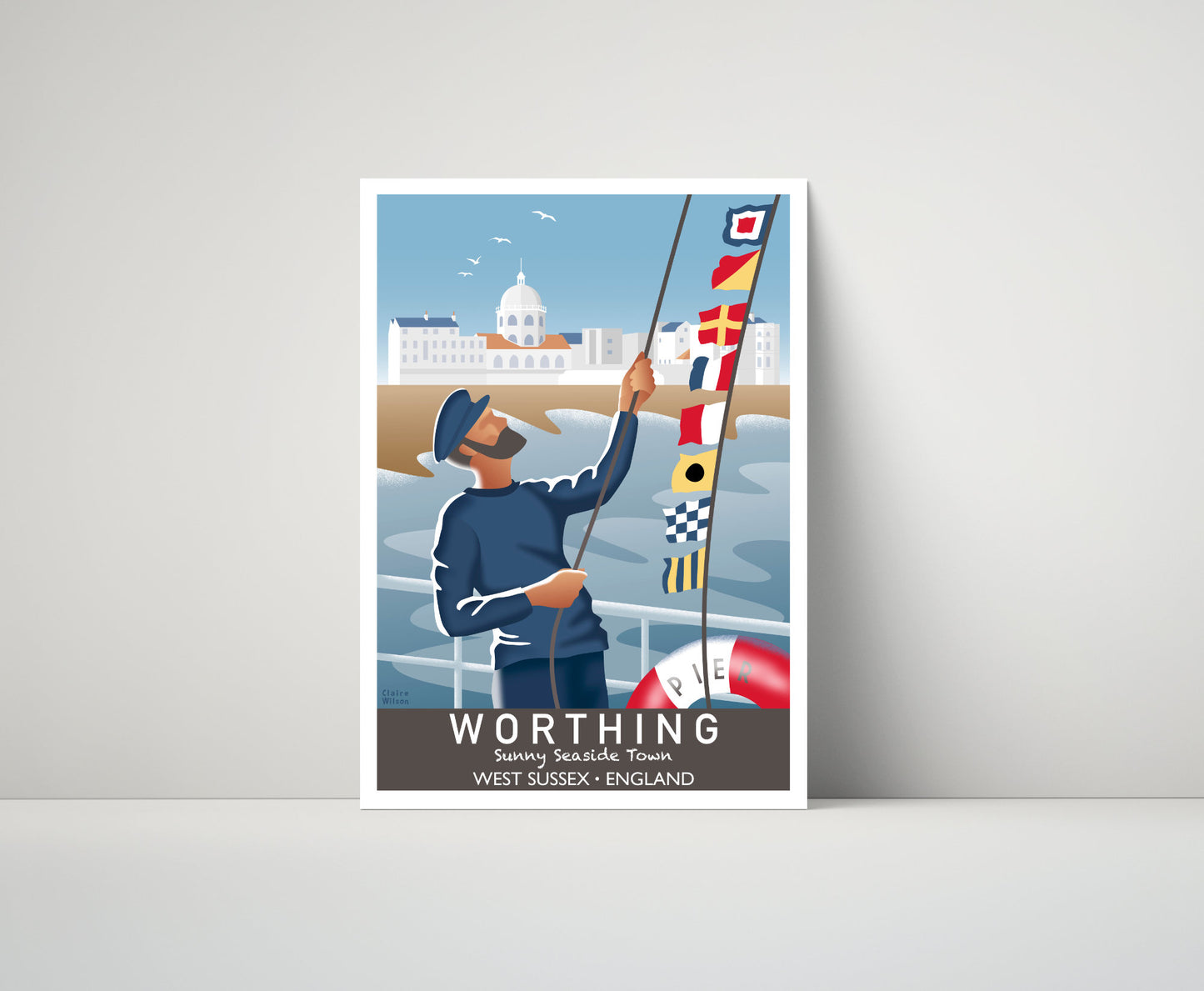 Artwork of a fisherman hoisting maritime flags on Worthing Pier, with a domed building and a seaside village in the distance 