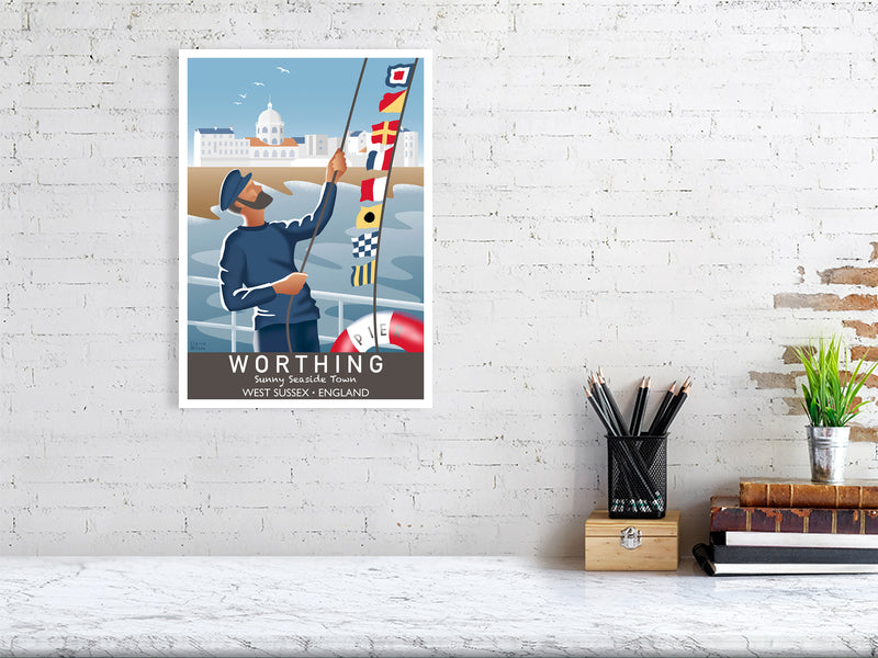 Artwork hanging on wall showing fisherman raising nautical flags on Worthing pier